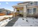 Two-story house with stone and gray siding, covered porch, and walkway at 6891 Longpark Dr, Parker, CO 80138