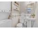 Bathroom with a toilet, pedestal sink, and tiled walls, featuring a stackable washer-dryer at 725 E Exposition Ave, Denver, CO 80209