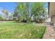 Large, grassy backyard with mature trees, patio, and perimeter fencing at 2743 S Reading Ct, Denver, CO 80231