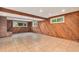 Finished basement featuring wood paneling, tile flooring, and a charming brick fireplace at 2743 S Reading Ct, Denver, CO 80231