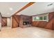 Finished basement with cozy brick fireplace and wood paneled walls at 2743 S Reading Ct, Denver, CO 80231