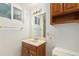 Bathroom with tile floor, toilet, sink, mirror, and wooden storage cabinet at 2743 S Reading Ct, Denver, CO 80231