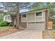 Home featuring a two-car garage, brick and siding, with mature trees at 2743 S Reading Ct, Denver, CO 80231