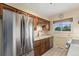 View of kitchen featuring stainless refrigerator, wood cabinets, updated appliances, and natural light at 2743 S Reading Ct, Denver, CO 80231