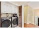 Well-organized laundry room with front-loading washer and dryer, and storage cabinets at 2743 S Reading Ct, Denver, CO 80231