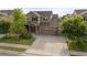 Suburban two-story home features a wide driveway, three-car garage and brick-accented front porch at 41 Jordan Ln, Erie, CO 80516