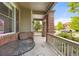 Charming covered front porch with seating area and brick pillars at 41 Jordan Ln, Erie, CO 80516
