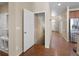 Hallway with hardwood floors, open door to basement, and stainless steel appliances in kitchen at 41 Jordan Ln, Erie, CO 80516