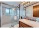 Well-lit bathroom showcasing a vanity sink and a glass-enclosed shower with tiled walls at 744 Memphis St, Aurora, CO 80011