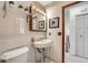 Cozy bathroom with tiled walls, classic sink, and decorative plants, complete with a framed mirror and a medicine cabinet at 744 Memphis St, Aurora, CO 80011