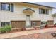 Inviting entryway featuring a well-manicured lawn and cozy landscaping around the front door at 744 Memphis St, Aurora, CO 80011