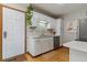 Galley kitchen with white cabinets, stainless steel appliances, and a garden view from the door at 1531 S Owens St # 23, Denver, CO 80232