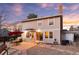 Two-story house with a patio area, outdoor seating, grill, and a well-maintained lawn under a colorful evening sky at 10200 Julian St, Westminster, CO 80031