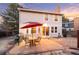 Back exterior view with a patio area, outdoor seating, and grill, set against a colorful sunset sky at 10200 Julian St, Westminster, CO 80031