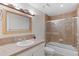 Full bathroom featuring a shower-tub combo with neutral-colored tile and a modern vanity at 10200 Julian St, Westminster, CO 80031