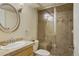Bathroom features tiled shower with seat, vanity and round mirror at 10200 Julian St, Westminster, CO 80031