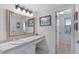 Bright bathroom featuring a large mirror, tiled vanity, and neutral décor at 10200 Julian St, Westminster, CO 80031