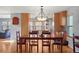 Elegant dining area connecting to a modern kitchen with wood cabinets and hardwood floors at 10200 Julian St, Westminster, CO 80031