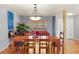Open dining room with a wooden table, seating for six, and views to the living area and kitchen at 10200 Julian St, Westminster, CO 80031
