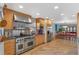 Open kitchen boasts stainless steel appliances, wood floors, and seamless flow to dining area at 10200 Julian St, Westminster, CO 80031
