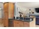 Kitchen island features granite countertops, stainless steel sink, and wood cabinetry at 10200 Julian St, Westminster, CO 80031