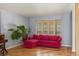 Comfortable living room with a red sectional couch, wood floors, and large windows for natural light at 10200 Julian St, Westminster, CO 80031
