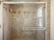 Tiled shower features glass door, neutral tile and in-shower storage at 10200 Julian St, Westminster, CO 80031