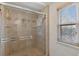 Tiled shower stall with a glass enclosure and a window for natural light at 10200 Julian St, Westminster, CO 80031