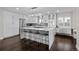 Modern kitchen with white cabinets, large island, and breakfast bar at 290 Glencoe St, Denver, CO 80220