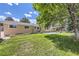 Exterior view of home with lush green lawn and backyard concrete patio at 8220 Lamar Cir, Arvada, CO 80003