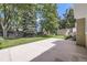 Spacious backyard with lush green lawn, a large concrete patio, mature trees and shed at 8220 Lamar Cir, Arvada, CO 80003