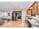 Open-concept kitchen with stainless steel appliances and granite countertops, seamlessly connecting to the adjacent living area at 8220 Lamar Cir, Arvada, CO 80003