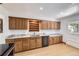 Functional kitchen features wood cabinets, stainless steel appliances, granite countertops, and an adjacent exterior door at 8220 Lamar Cir, Arvada, CO 80003