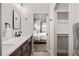 Bathroom with long white quartz countertop, wood cabinets, and view of the bedroom at 4180 Kalamath St, Denver, CO 80211