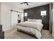 Comfortable bedroom featuring unique headboard wall, carpet floors, and sliding barn door to the bath at 4180 Kalamath St, Denver, CO 80211