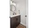 Stylish powder room featuring a sleek round mirror, modern lighting, and a dark wood vanity at 4180 Kalamath St, Denver, CO 80211