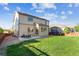 Spacious backyard with lawn, patio, dining set, and privacy fence at 802 Gamble Oak St, Brighton, CO 80601
