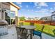 Landscaped backyard with well-manicured lawn, patio dining set, and privacy fence at 802 Gamble Oak St, Brighton, CO 80601