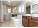 Bright bathroom featuring a tiled floor, a large soaking tub, and dual vanity sinks at 802 Gamble Oak St, Brighton, CO 80601