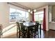 Bright dining room featuring a dark wood table and chairs with large windows for natural light at 802 Gamble Oak St, Brighton, CO 80601