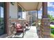 Charming front porch with stone columns and two chairs with red cushions at 802 Gamble Oak St, Brighton, CO 80601