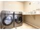 Laundry room featuring front loading washer and dryer, shelf, and neutral colors at 802 Gamble Oak St, Brighton, CO 80601