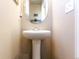 Simple powder room featuring a pedestal sink with a mirror and neutral walls at 802 Gamble Oak St, Brighton, CO 80601