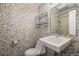 The bathroom features mosaic tile and a corner sink, with a chrome shelving unit for storage at 500 E 11Th Ave # 102, Denver, CO 80203
