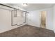 A carpeted bedroom with a window and a doorway to a bathroom with a mosaic tile design at 500 E 11Th Ave # 102, Denver, CO 80203