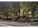 An exterior view of a multi-unit residential building on a tree-lined street with many parked cars at 500 E 11Th Ave # 102, Denver, CO 80203
