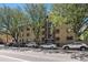 An exterior view of a multi-unit residential building on a tree-lined street with many parked cars at 500 E 11Th Ave # 102, Denver, CO 80203