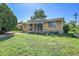 View of a well-maintained home featuring a lush green lawn under a bright blue sky at 9095 Beechwood Dr, Thornton, CO 80229