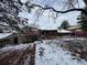 Inviting backyard features a brick patio, shed, and lush greenery; partially covered in snow at 3770 S Ulster St, Denver, CO 80237