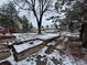 Expansive backyard with mature trees, garden beds, and a fence offering privacy. Covered in snow at 3770 S Ulster St, Denver, CO 80237